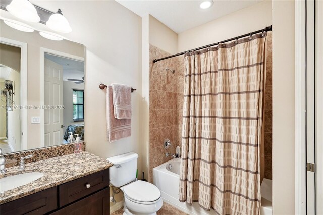 full bathroom featuring vanity, shower / bath combination with curtain, and toilet