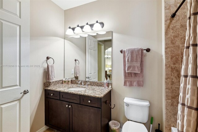 bathroom featuring a shower with curtain, vanity, and toilet