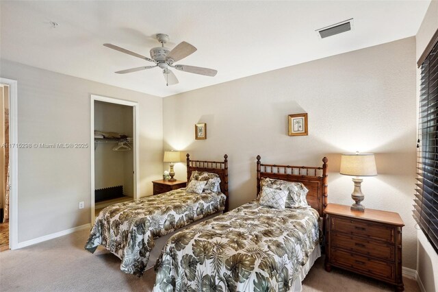 carpeted bedroom featuring ceiling fan, a closet, and a spacious closet