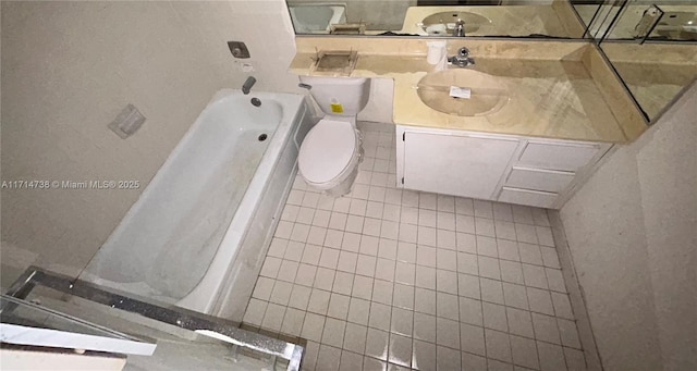 bathroom featuring tile patterned flooring, vanity, a tub to relax in, and toilet