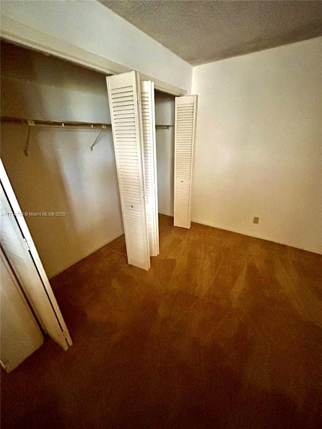 unfurnished bedroom featuring carpet floors and two closets