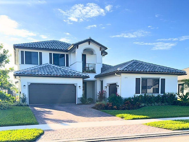 view of front of property featuring a balcony, a front yard, and a garage