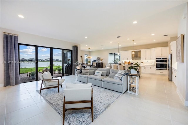 living room with a water view and light tile patterned flooring