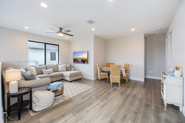 living room featuring ceiling fan and wood-type flooring