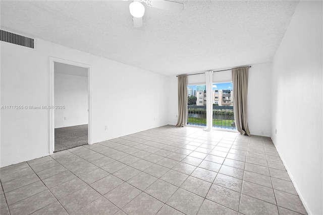 unfurnished room with light tile patterned floors, a textured ceiling, and ceiling fan