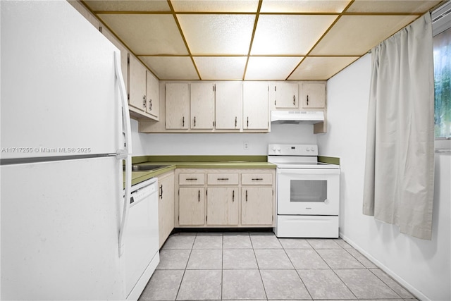 kitchen featuring cream cabinets, light tile patterned flooring, white appliances, and sink