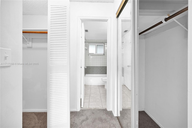 spacious closet featuring light colored carpet