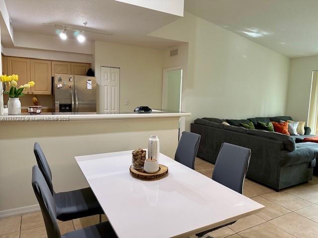 tiled dining area featuring track lighting