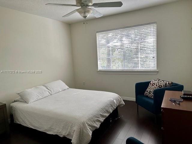 bedroom with ceiling fan and dark wood-type flooring