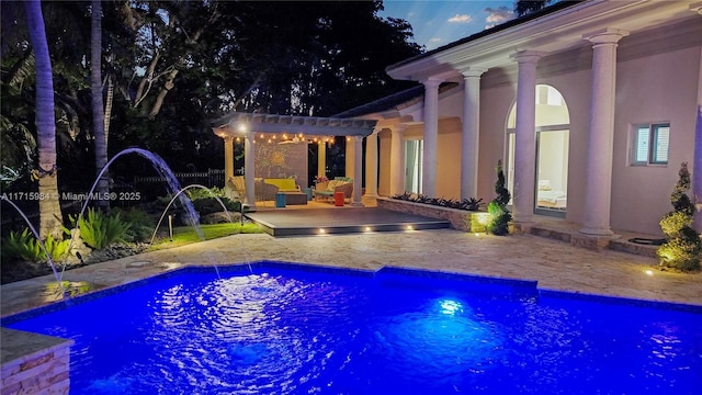 view of swimming pool with pool water feature, a patio, a pergola, and a wooden deck