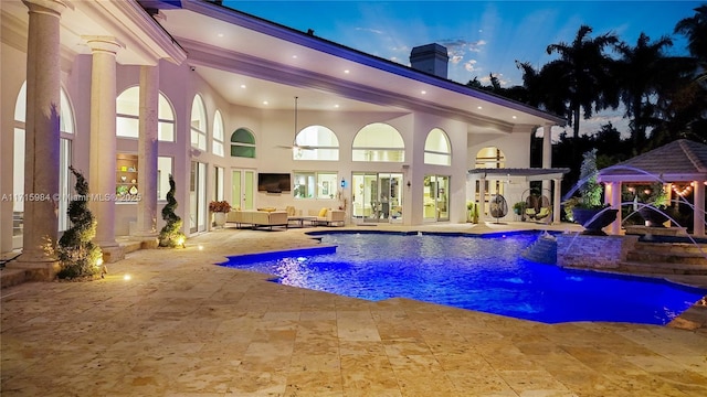 view of swimming pool featuring outdoor lounge area, ceiling fan, and a patio area