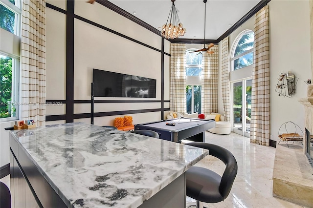 interior space featuring crown molding, billiards, decorative light fixtures, and an inviting chandelier