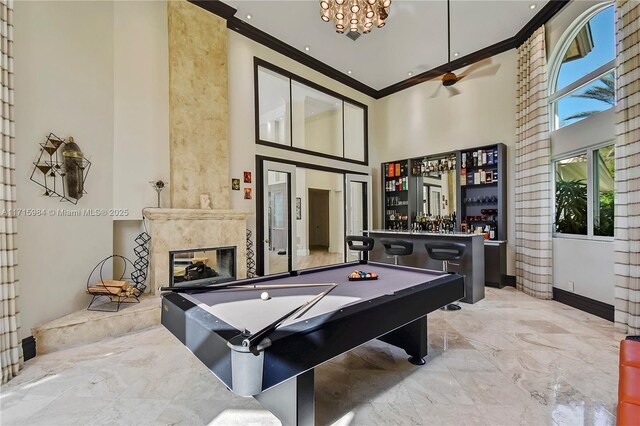 game room featuring billiards, ceiling fan, crown molding, indoor bar, and a premium fireplace