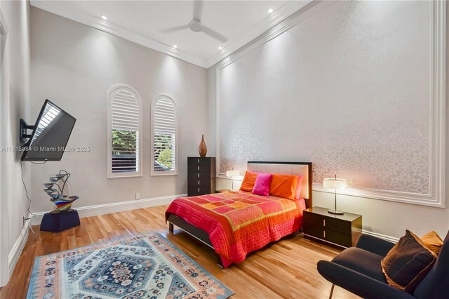 bedroom with wood-type flooring, ceiling fan, and crown molding