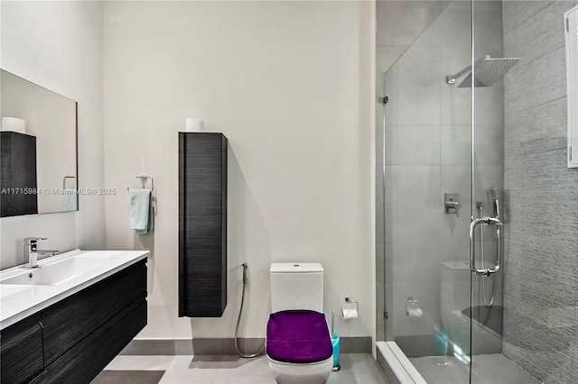 bathroom featuring tile patterned flooring, vanity, toilet, and a shower with door