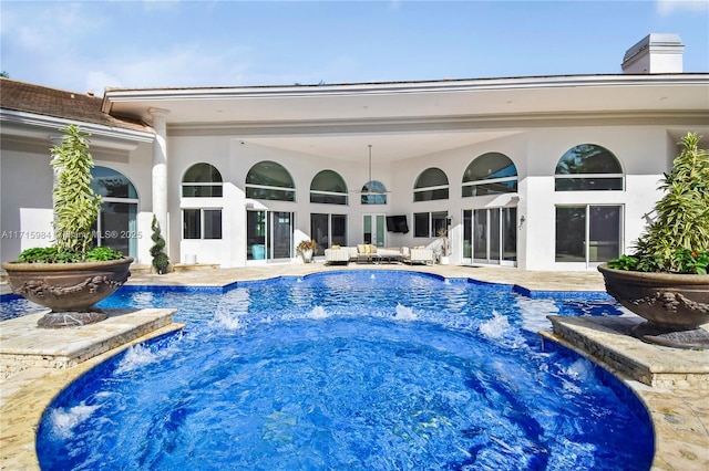 view of pool featuring outdoor lounge area, a patio, and pool water feature