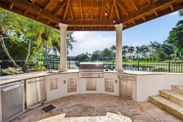 view of patio / terrace with grilling area, a water view, sink, a gazebo, and area for grilling