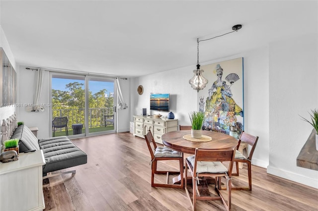 dining space with light wood-type flooring and expansive windows