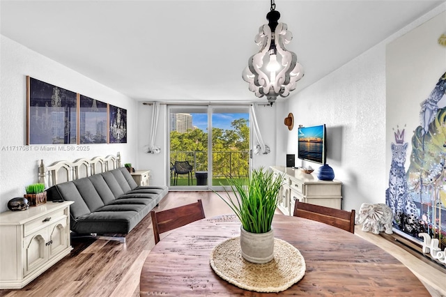 dining space featuring light hardwood / wood-style flooring, expansive windows, and a notable chandelier