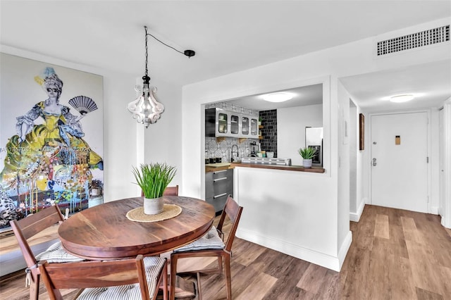 dining area featuring light wood-type flooring and wet bar