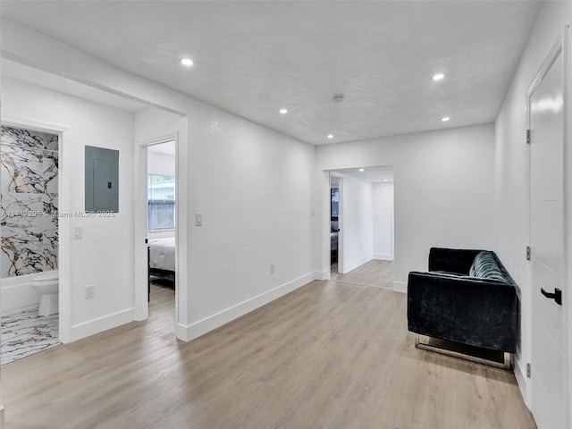 living area featuring electric panel and light wood-type flooring