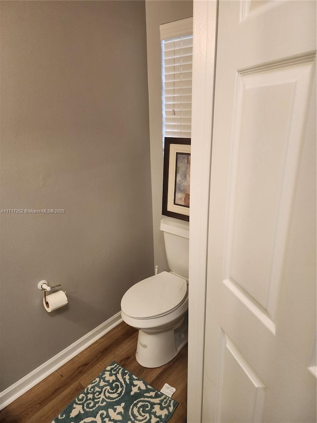 bathroom featuring toilet and wood-type flooring