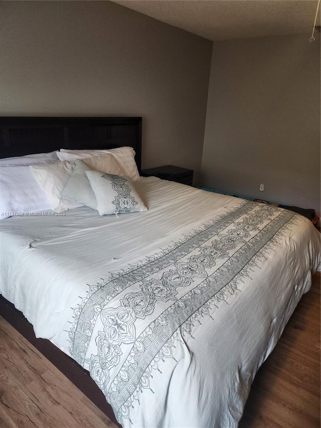 bedroom with dark wood-type flooring