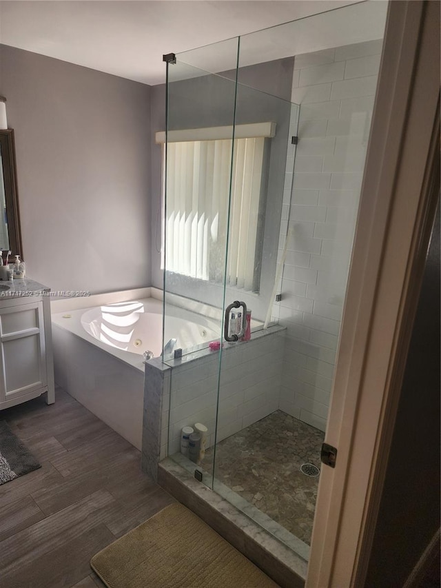 bathroom with independent shower and bath, wood-type flooring, and vanity