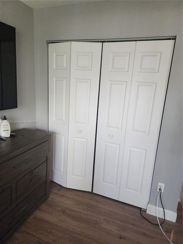 bedroom featuring a closet and dark wood-type flooring