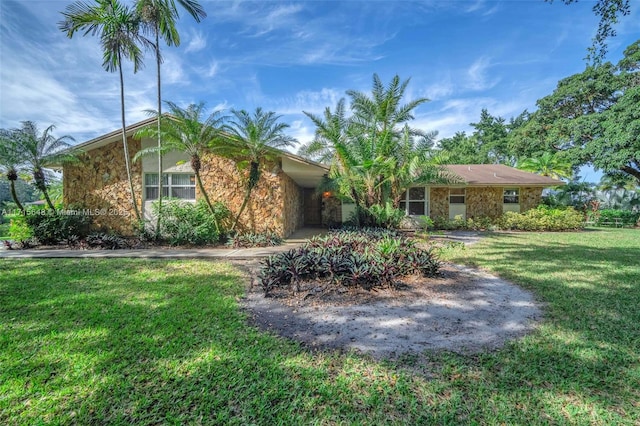 single story home with a front yard and a carport