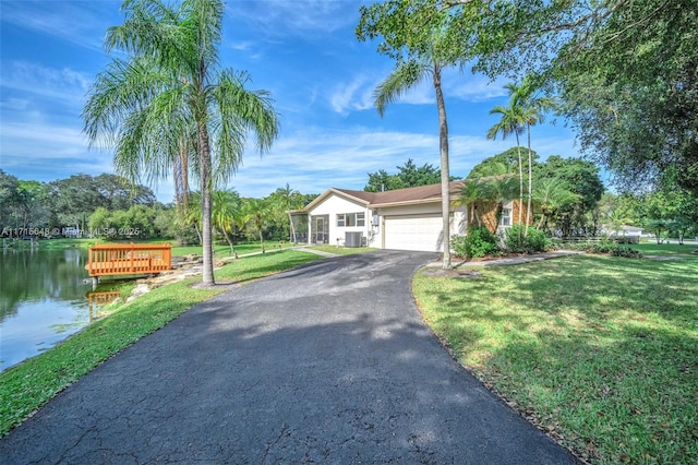 single story home featuring a garage, a water view, and a front yard