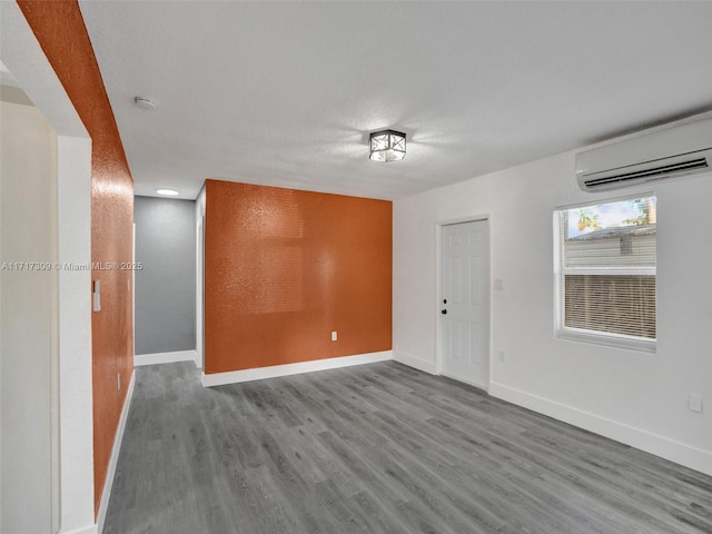 spare room with a wall unit AC and hardwood / wood-style flooring