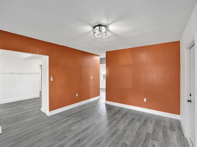 unfurnished room featuring a textured ceiling and hardwood / wood-style floors