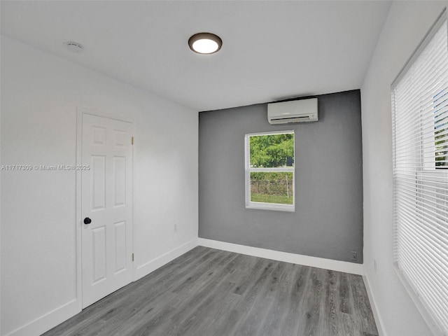 empty room featuring a wall unit AC and hardwood / wood-style floors