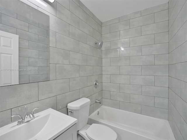 full bathroom featuring toilet, vanity, tile walls, and tiled shower / bath