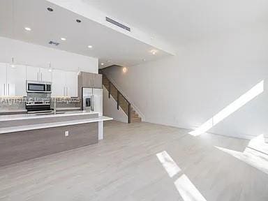 interior space featuring visible vents, backsplash, appliances with stainless steel finishes, a sink, and modern cabinets