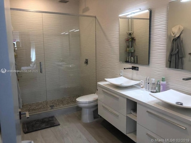 bathroom featuring backsplash, a sink, toilet, and a shower stall