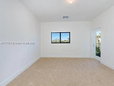 unfurnished room with light carpet, visible vents, a wealth of natural light, and baseboards