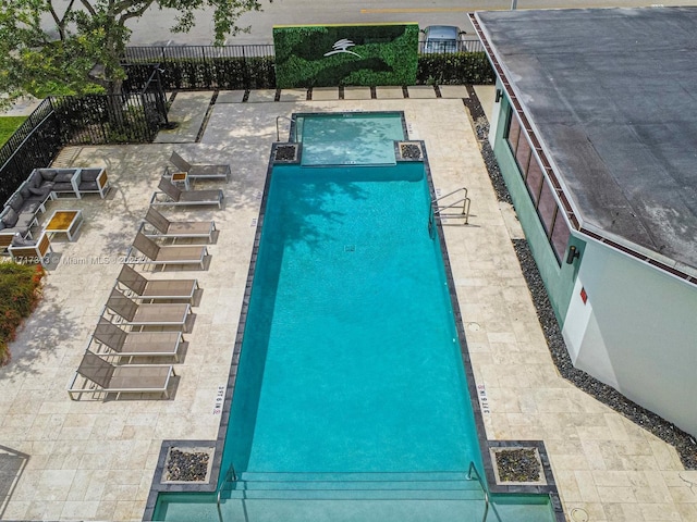 community pool with fence and a patio