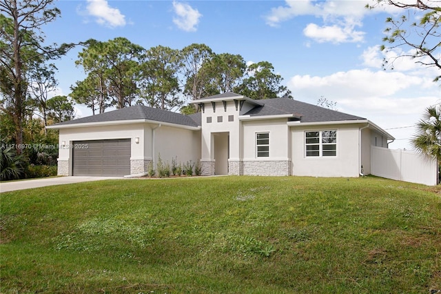 prairie-style house with fence, an attached garage, stucco siding, a front lawn, and concrete driveway