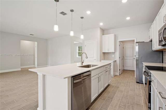 kitchen featuring visible vents, a sink, decorative backsplash, light countertops, and appliances with stainless steel finishes