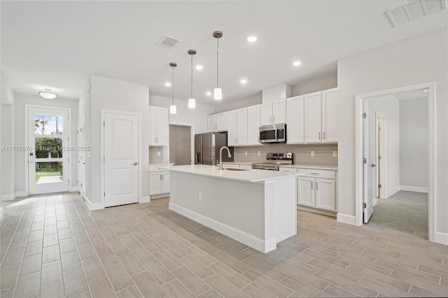 kitchen featuring a sink, visible vents, backsplash, and appliances with stainless steel finishes