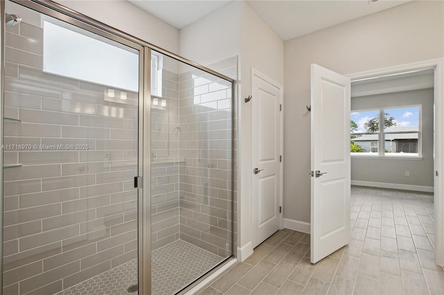 full bathroom featuring a shower stall and baseboards