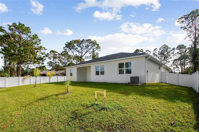 back of property featuring a lawn, cooling unit, a fenced backyard, and stucco siding