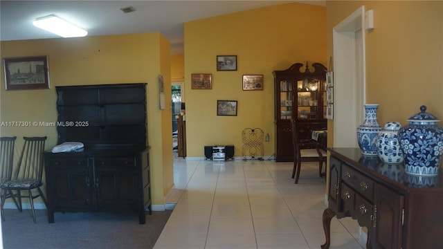 corridor featuring baseboards, visible vents, and tile patterned floors