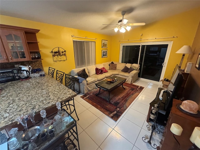 living room with light tile patterned floors, ceiling fan, and a toaster