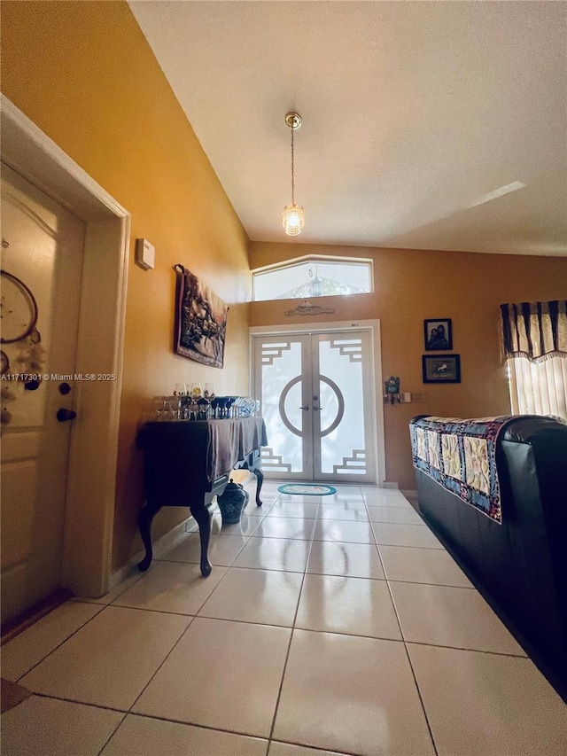 tiled entryway featuring french doors and lofted ceiling