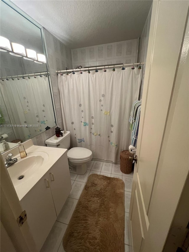 full bath with curtained shower, toilet, a textured ceiling, vanity, and tile patterned floors