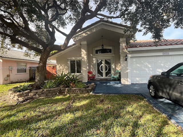 view of front of property with a tiled roof, an attached garage, fence, a front lawn, and stucco siding