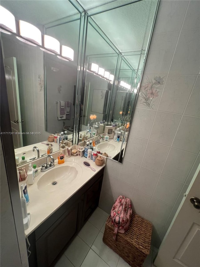 bathroom with tile walls, vanity, and tile patterned flooring